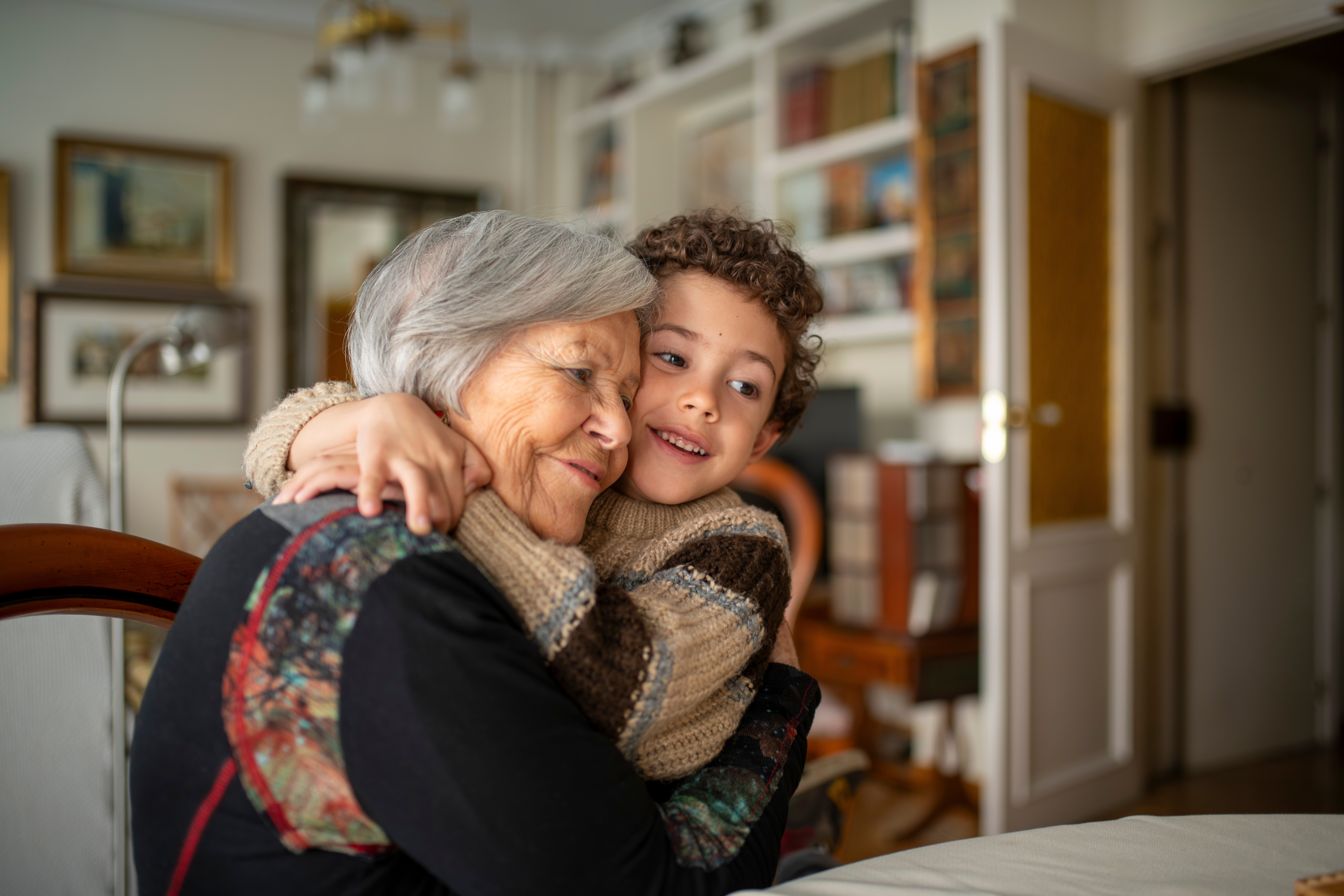 Grandchild embracing grandmother.