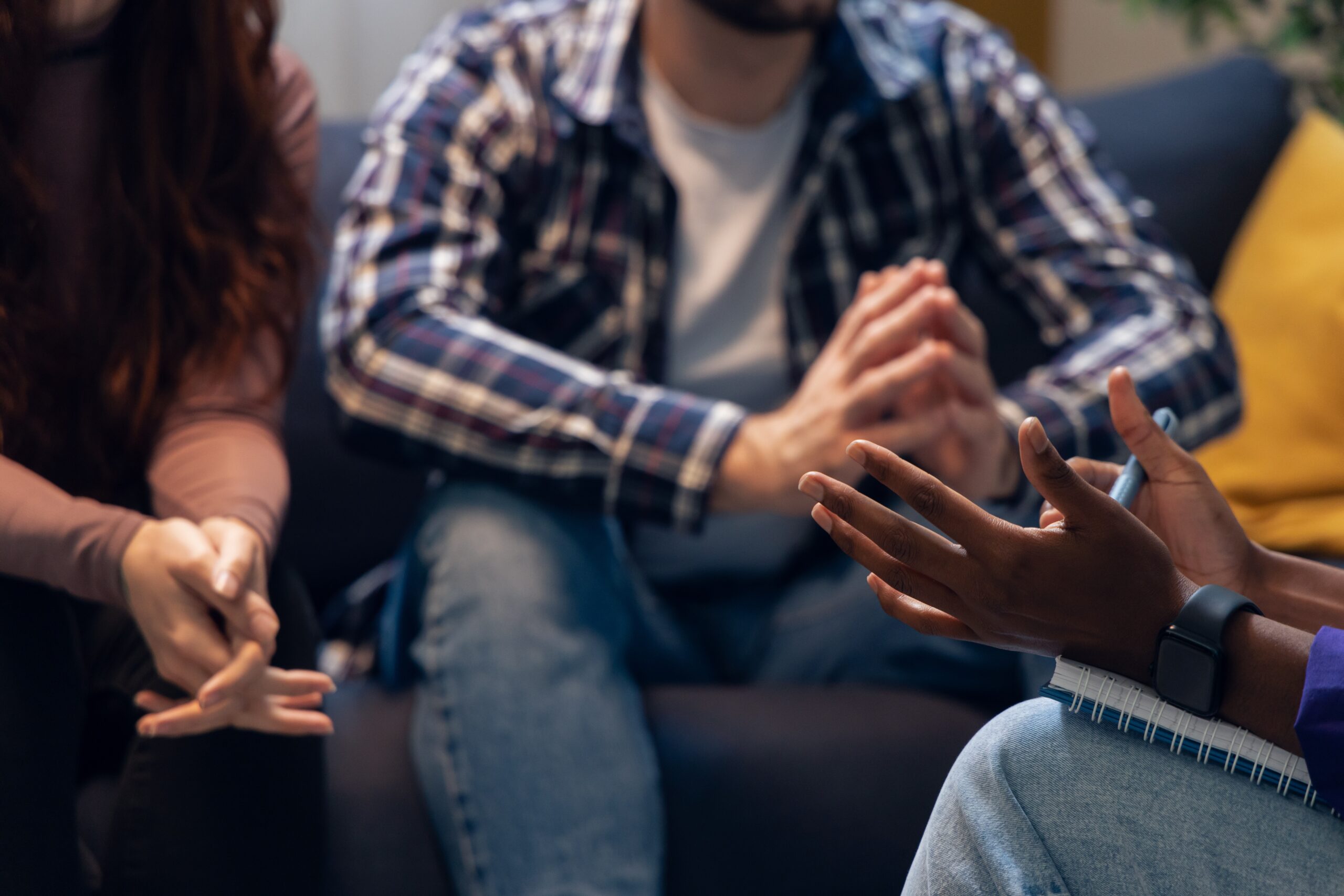 Member of staff communicating with a nervous couple during a support group.